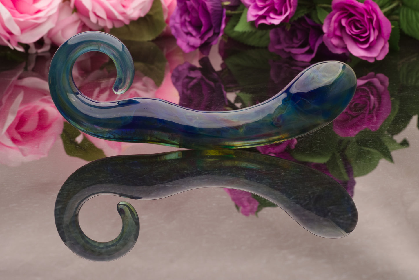 A handmade glass sex toy made by glassblowers in the USA! This one offers rainbow tones with blues, greens and purples.